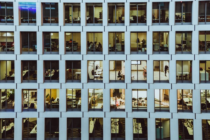 Office building windows with people working inside