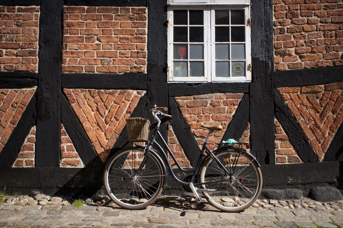 Bicycle parked against a timber-framed brick wall in Denmark