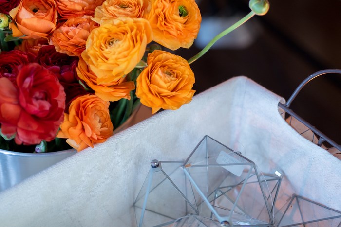 Orange and red ranunculus flowers in a bucket