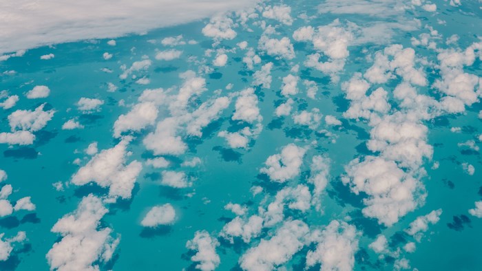 Aerial view of clouds over turquoise ocean water