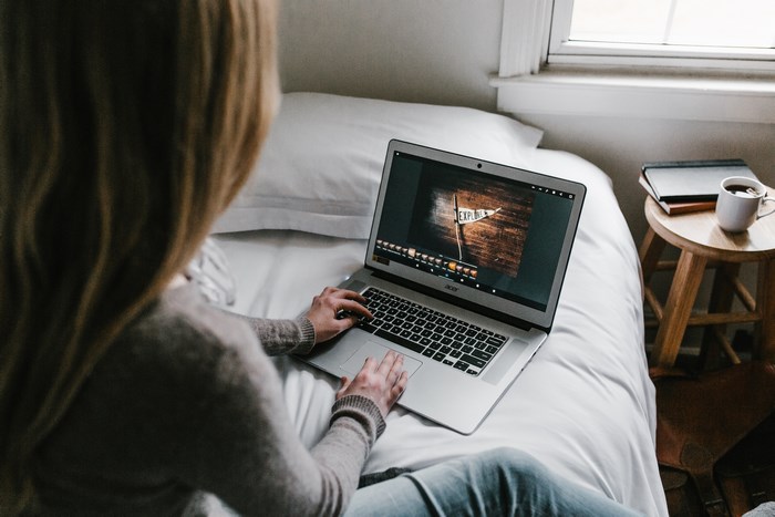 Woman working on Acer laptop in bed