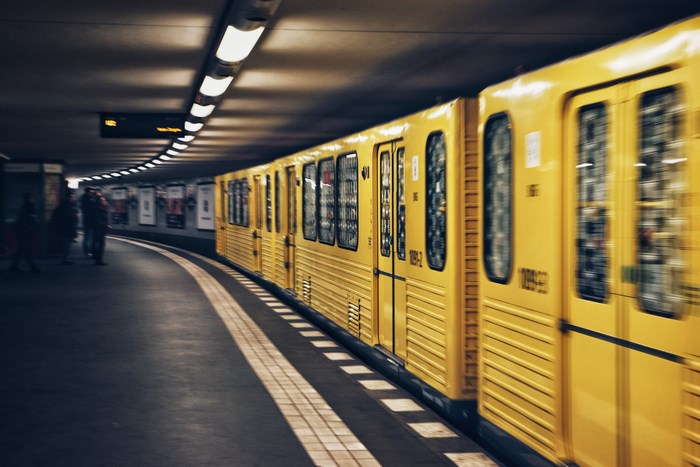 Yellow subway train on a curved platform