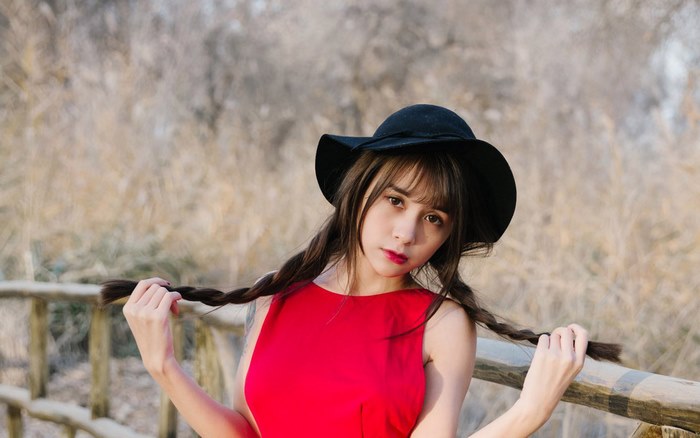 Model Xia Mei Jiang wearing a red dress and black hat