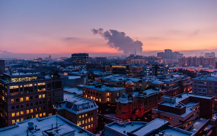 City skyline at dusk with snow-covered rooftops
