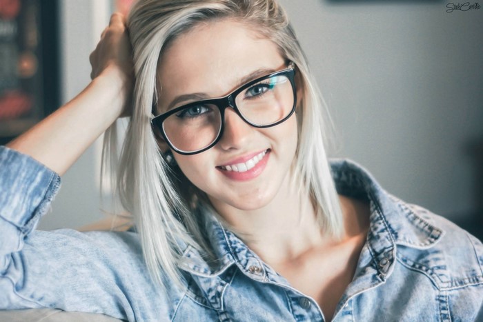Woman with blonde hair and glasses smiling