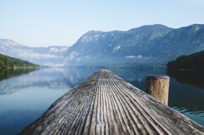 Wooden pier on a calm lake with mountains