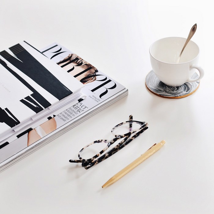 Porter magazine, glasses, and coffee cup on a white table