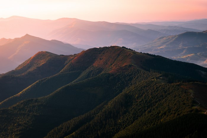 Mountain range with forest and sunset sky
