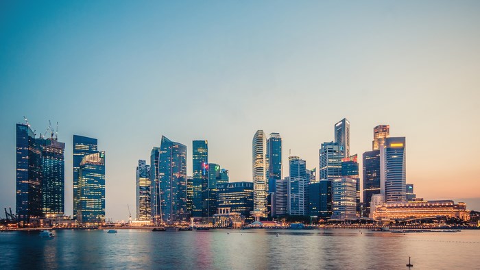 Singapore skyline at dusk with boats on the water