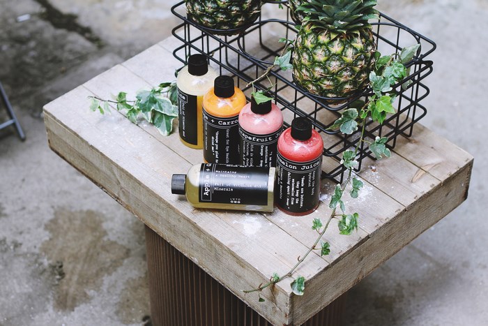 Bottled Juices and Pineapples on a Wooden Board