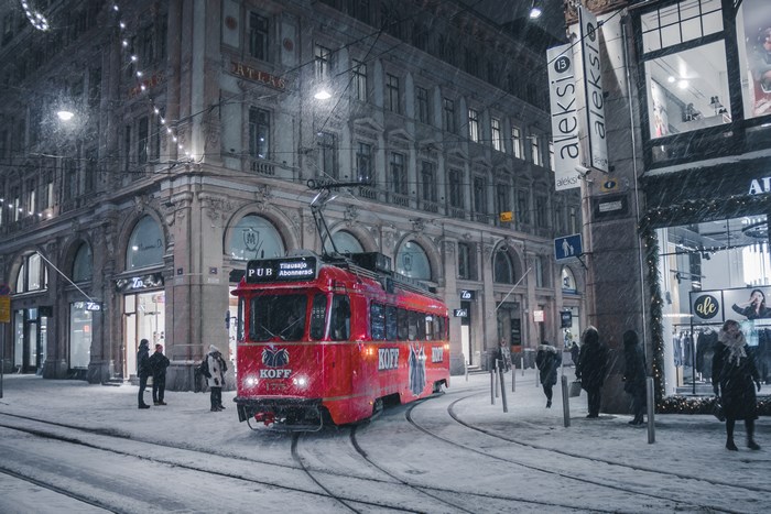 Red tram in Helsinki during snowfall