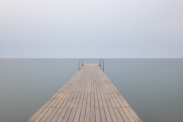 Wooden pier extending into the calm sea under a clear sky