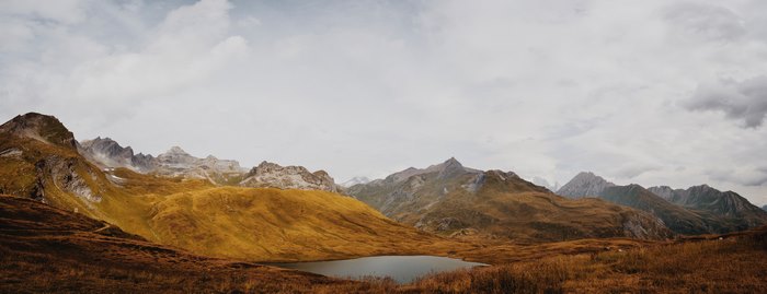 Mountain range with a lake and golden hills