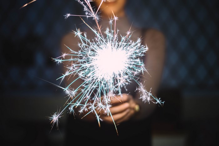 Woman holding a sparkler with a dark background