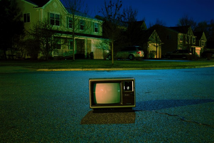 Vintage television on a suburban street at night