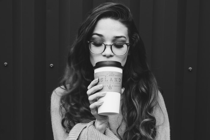 Woman in glasses drinking coffee from a cup