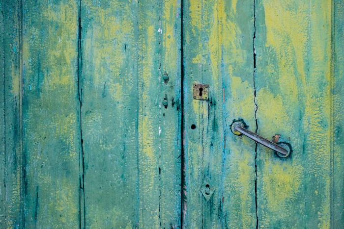 Old green wooden door with lock and handle