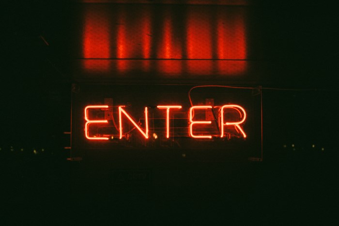 Red neon sign that says ENTER