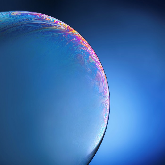 Abstract soap bubble with colorful swirls on blue background