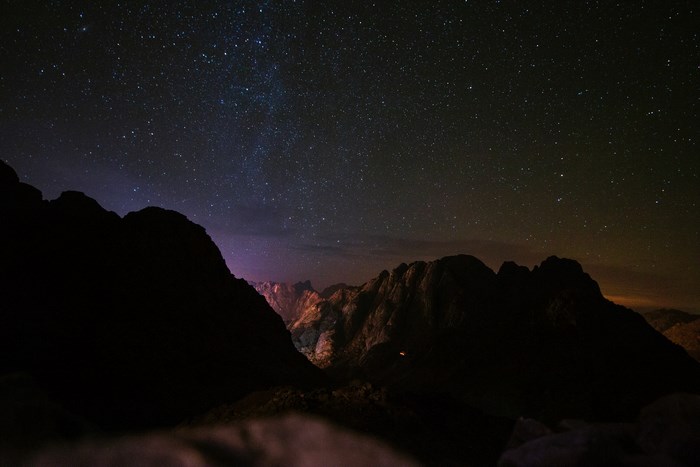Silhouette of mountains under a starry night sky