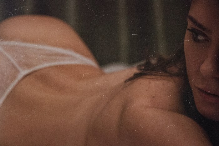 Nude girl lying down in intimate setting