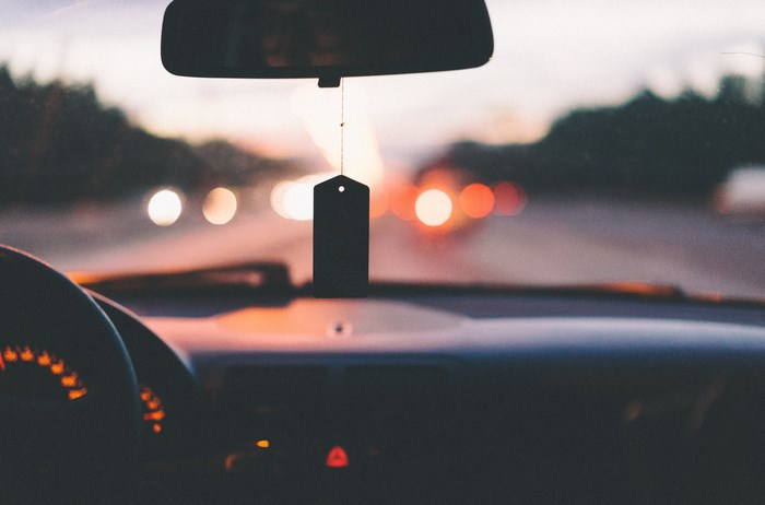 Car interior with air freshener and dashboard at dusk