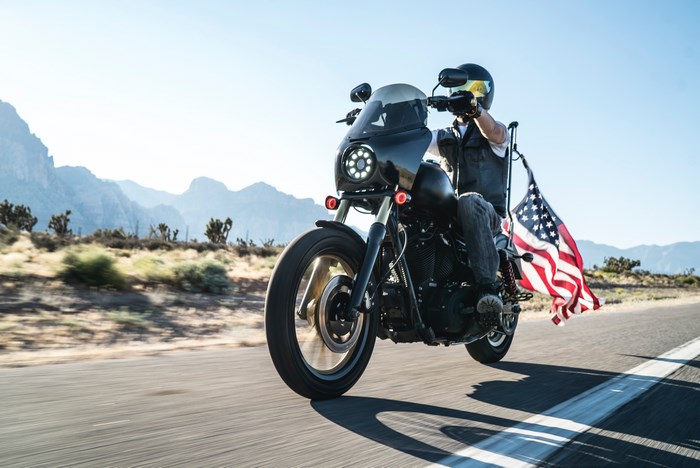 Motorcyclist with American Flag on Desert Road