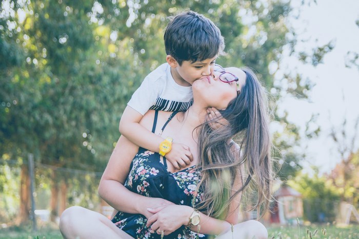 Mother and Son Sharing a Loving Kiss Outdoors