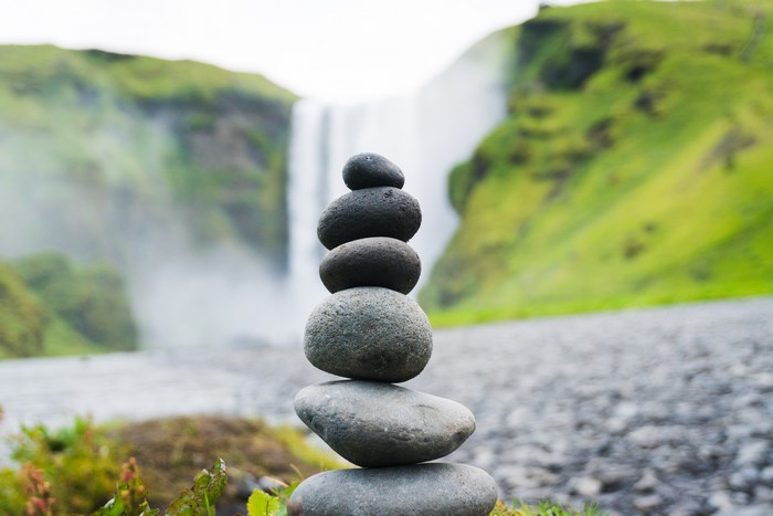 Stack of stones in front of a waterfall