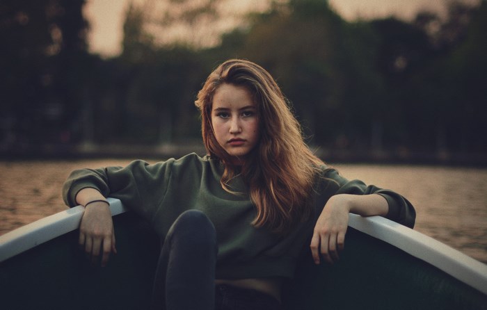 Girl sitting in a boat at dusk