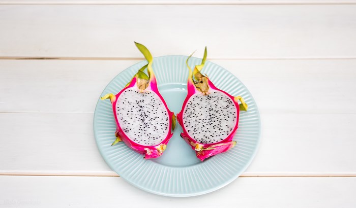 Two halves of dragon fruit on a blue plate