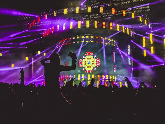 Crowd at a concert with purple and yellow lights
