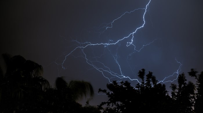 Lightning strikes across a dark, stormy night sky