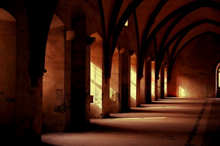 Sunlit Gothic Cloister with Archways and Shadows