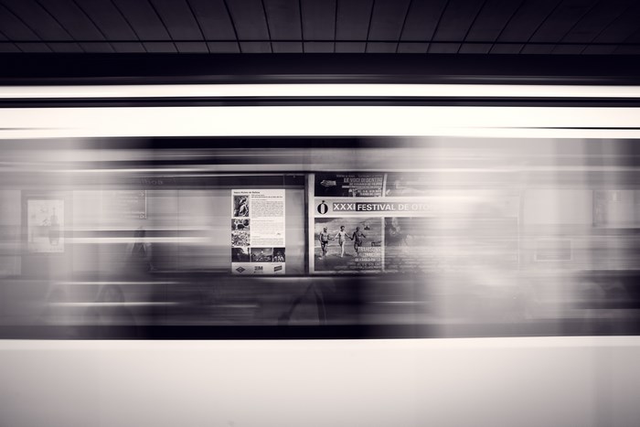 Blurred train window with posters in monochrome