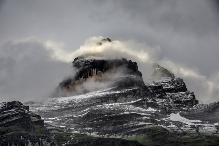 Misty mountain peak with snow and clouds