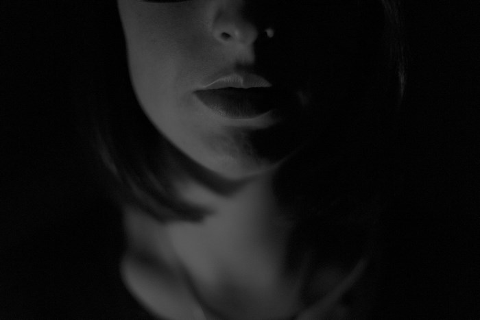 Close-up of a woman's lips and chin in shadow