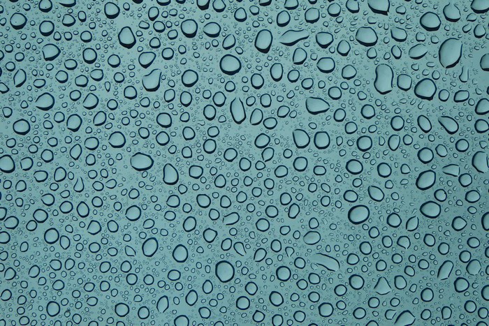 Water droplets on a blue glass surface