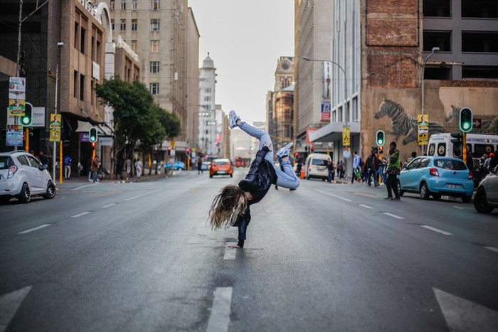 Woman breakdancing in the middle of a city street
