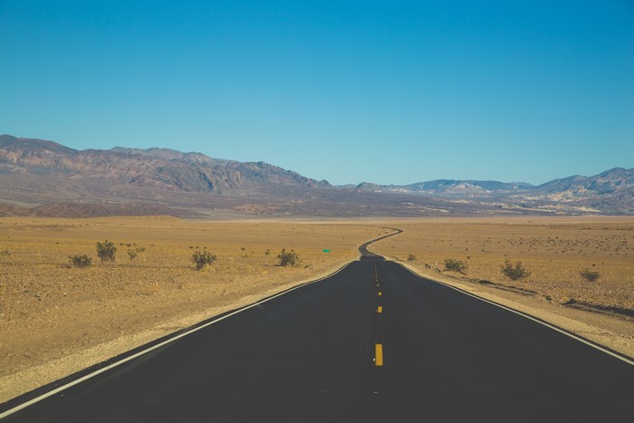 Desert highway with mountains and blue sky