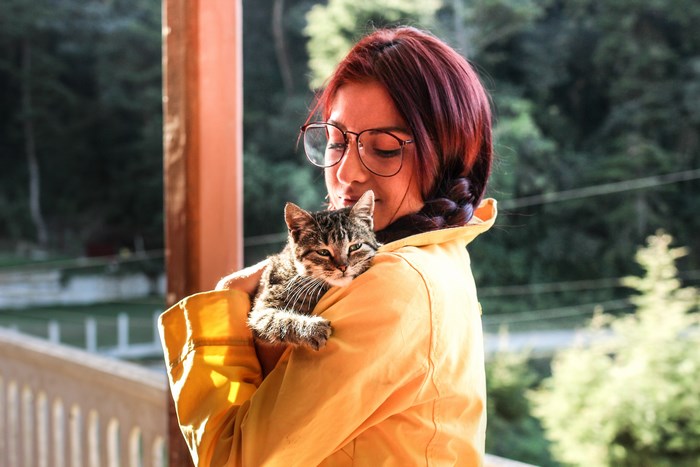 Woman in yellow raincoat holding a cat