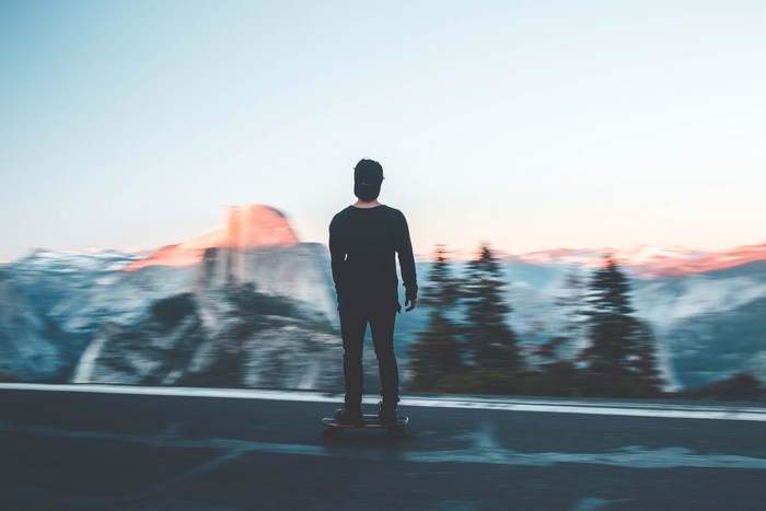 Man on skateboard with Half Dome in Yosemite Valley