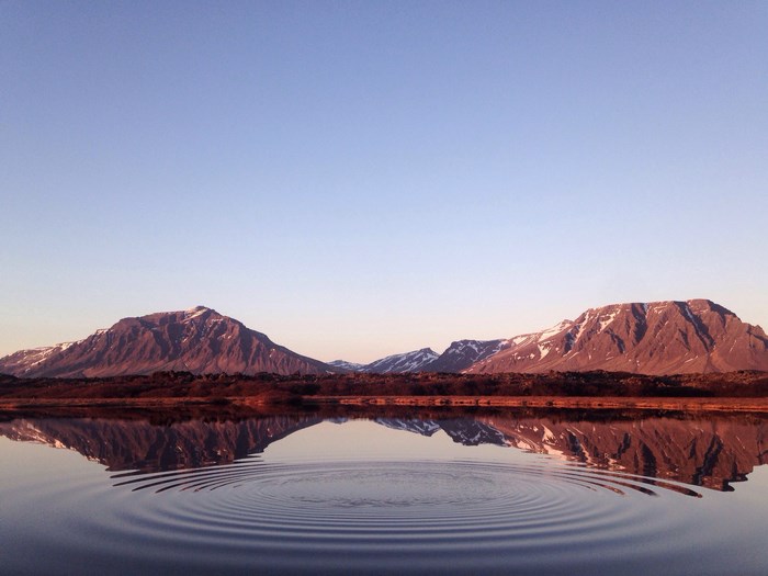 Mountain range reflection on calm lake in Iceland