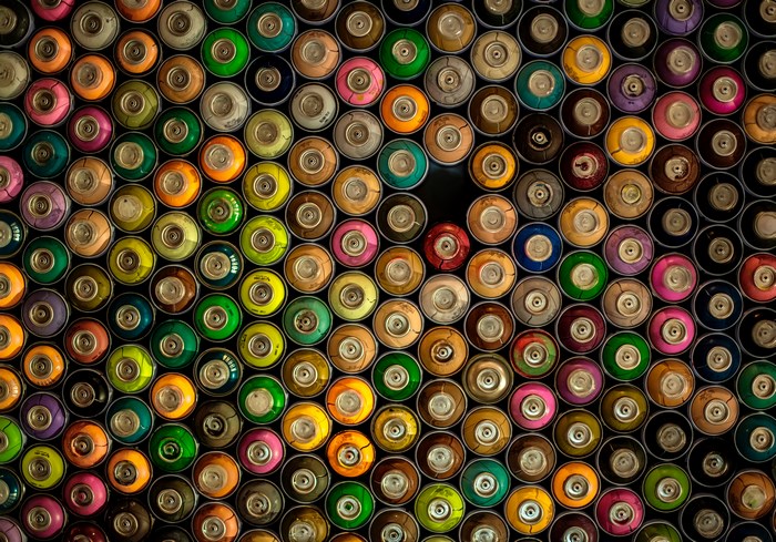 Colorful spray paint cans arranged in a pattern
