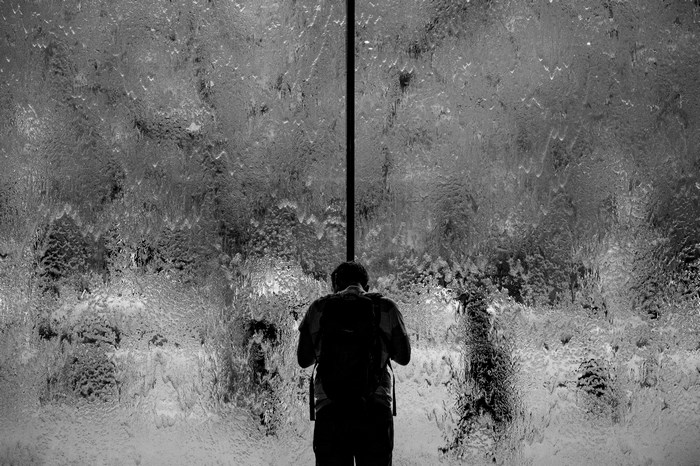 Man with backpack looking at a waterfall