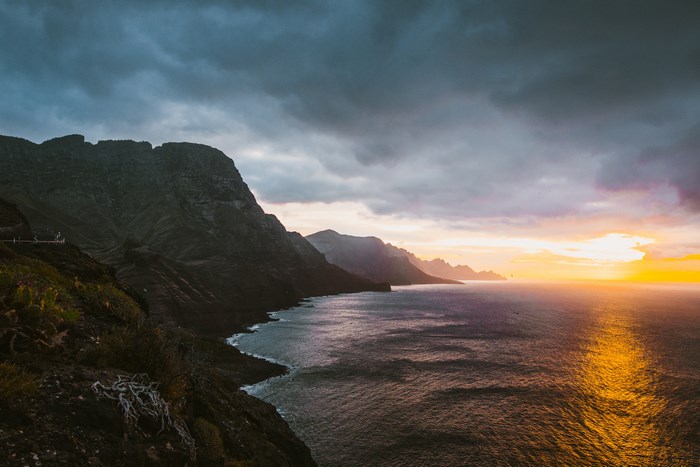 Sunset Over Rocky Coastal Cliffs with Dramatic Clouds in Thailand