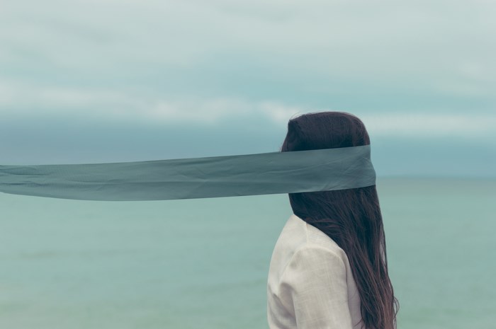 Woman with blindfold by the sea