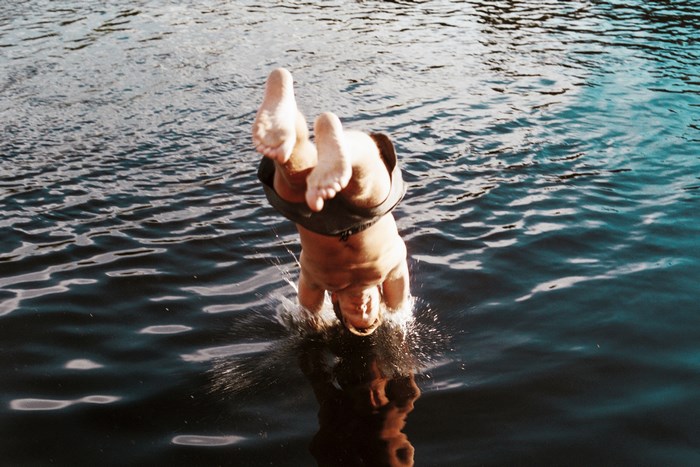 A person dives into a lake, creating a splash