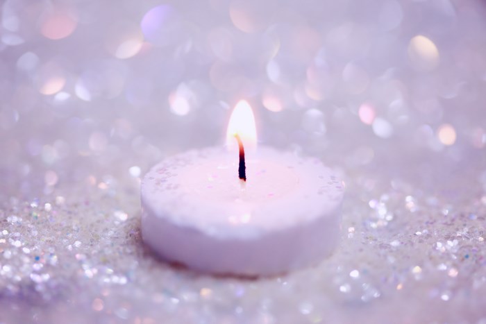 Close-up of a lit candle on glitter