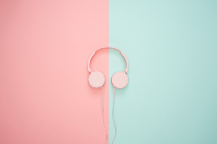 Pink headphones on a pastel pink and blue background
